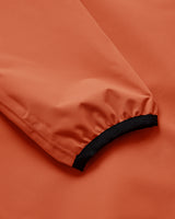 Close-up of an orange fabric sleeve or garment section with a black elasticized cuff.