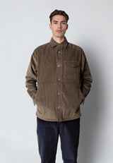Man wearing a brown corduroy jacket against a plain background