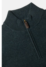 Close-up of a dark teal knit quarter-zip sweater with a brown leather zipper pull, shown against a light gray background.