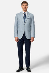 Man wearing a light blue checkered blazer over a dark blue dress shirt with a white background