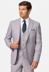 Man wearing a blush checkered suit with a white shirt and dark tie on a white background