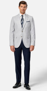Man wearing a light gray suit with navy pants on a white background