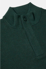 A close-up of a black faux fur or fur textile with soft, plush texture and a small dark brand tag near the center, photographed against a plain light background.