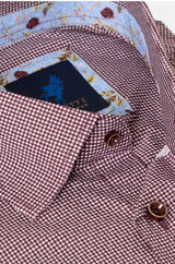 Close-up of a men's dress shirt collar showing a red and white micro gingham pattern, a light blue floral inner collar lining, and a dark navy brand label with a blue horse logo.