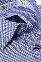 Close-up of a blue and white gingham patterned dress shirt with a patterned inner collar lining and dark buttons.