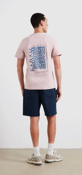 Person wearing a pink t-shirt with a QR code design on the back, standing against a white background.