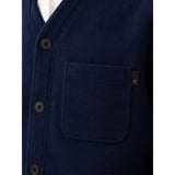 Close-up of a navy blue button-front cardigan or sweater with a chest pocket and a small black tag featuring a white X logo, shown against a white background.