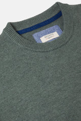 Green sweater with a visible brand label on a light gray background
