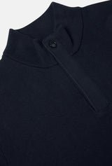 Close-up of a dark blue garment with a button on a light gray background