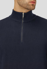 Navy blue ribbed sweater with a quarter zip on a neutral background