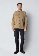 Man wearing a beige jacket and black pants on a white background