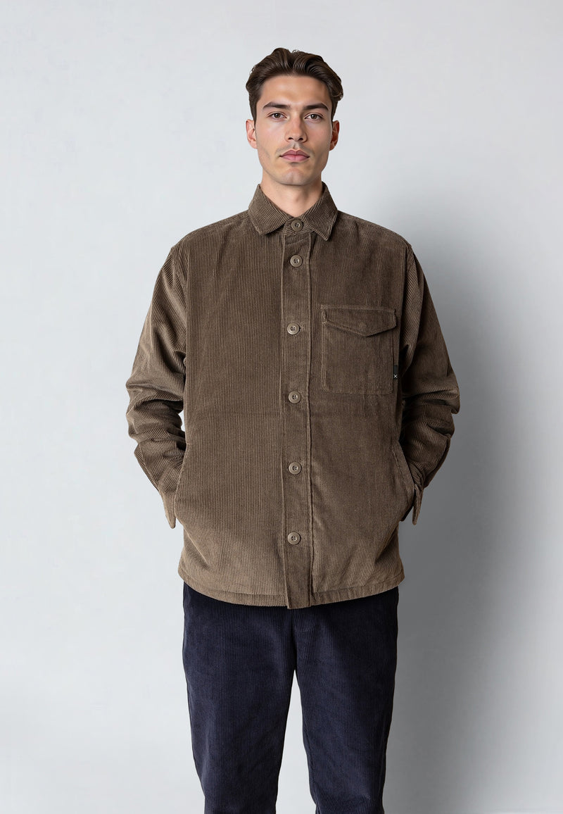 Man wearing a brown corduroy jacket against a plain background