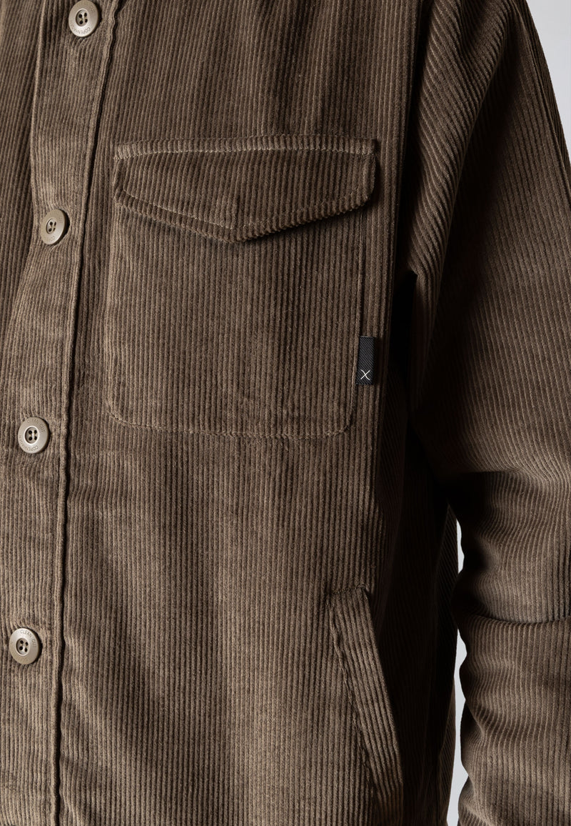 Brown corduroy shirt with buttons and a pocket on a white background