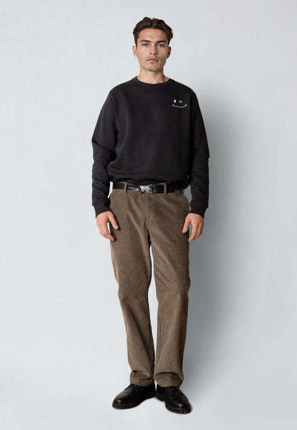 Man wearing a black sweatshirt and brown pants on a white background