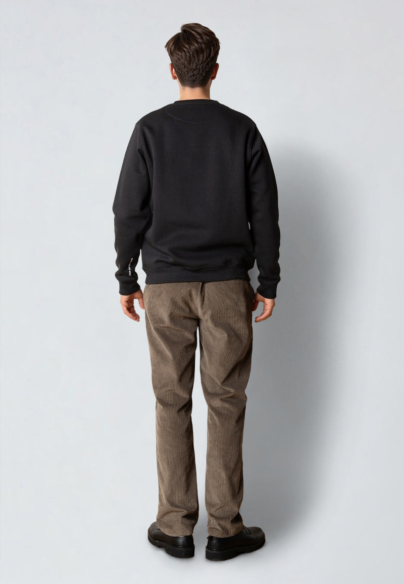 Person wearing a black sweatshirt and brown pants on a white background