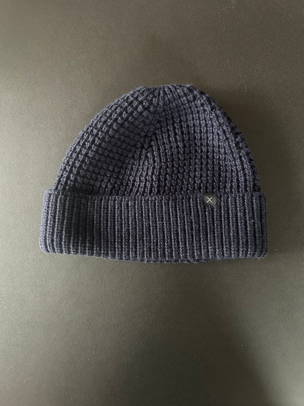 Navy knit beanie on a beige background