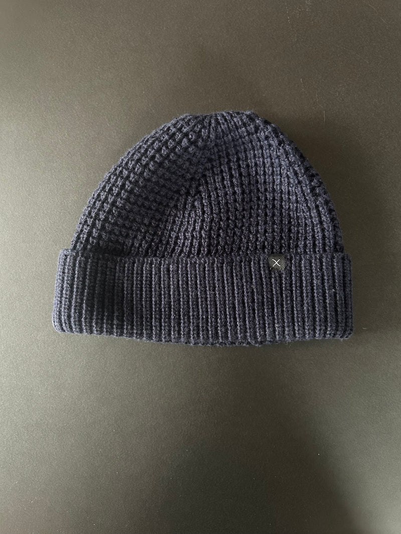 Navy knit beanie on a beige background