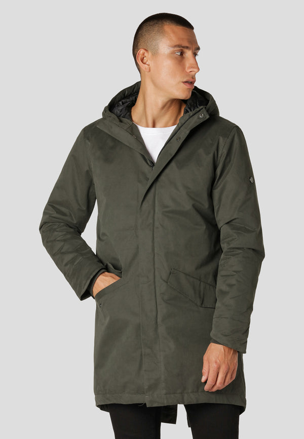Man wearing a green raincoat on a light gray background