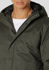 Person wearing a dark green coat with a hood, close-up view.