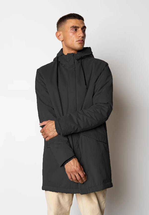 Man wearing a black coat against a white background