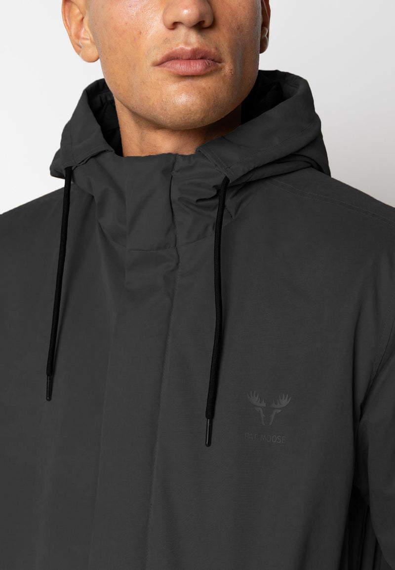 Person wearing a black hooded jacket with a brand logo on a plain background
