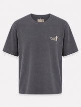 A dark gray washed short-sleeve t-shirt with a small beige graphic on the left chest, displayed against a light gray background.