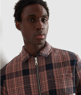 Man wearing a plaid jacket against a neutral background
