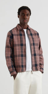 Person wearing a plaid shirt over a white t-shirt on a plain background