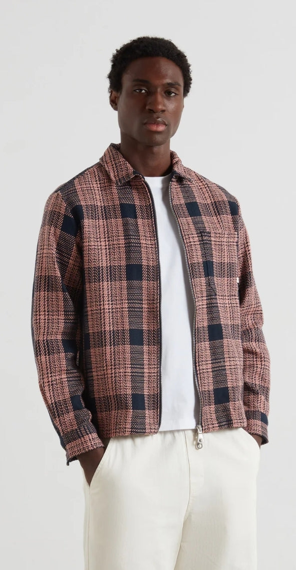 Person wearing a plaid shirt over a white t-shirt on a plain background