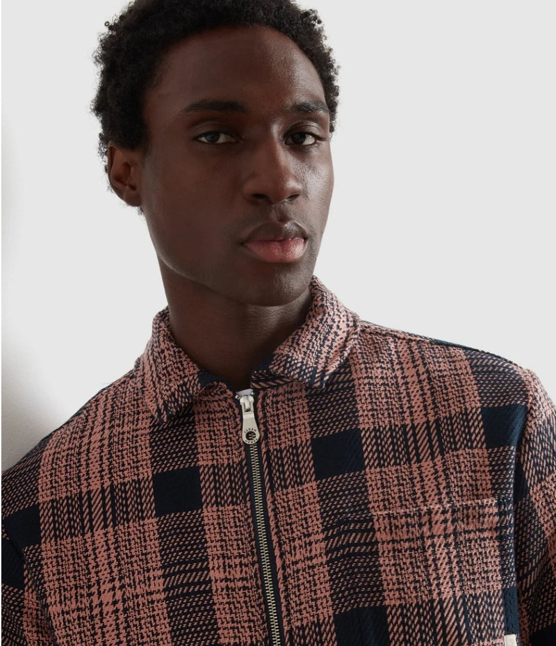 Man wearing a plaid jacket against a neutral background