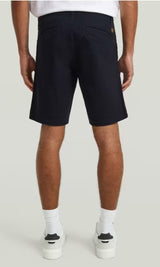 Person wearing navy shorts on a plain background