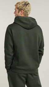Person wearing a green hoodie and pants on a plain background