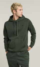 Man wearing a green hoodie on a plain background
