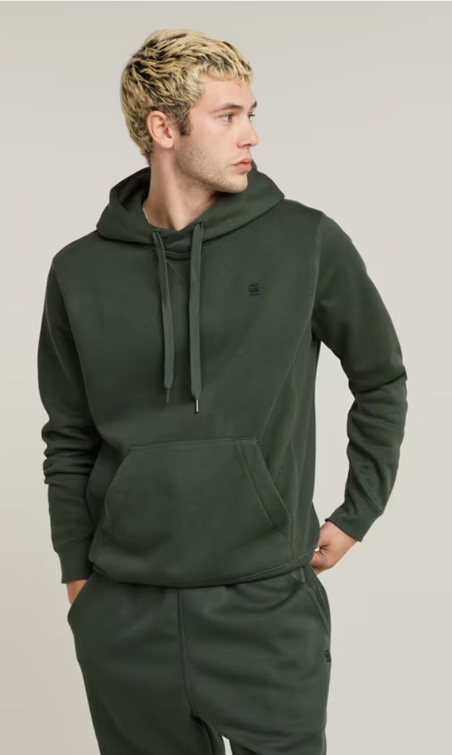 Man wearing a green hoodie on a plain background