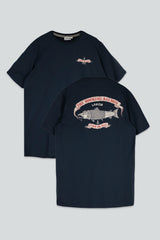 A navy blue short-sleeve t-shirt shown from both the front and back against a light gray background. The front features a small pink and white graphic on the left chest, while the back displays a large graphic of a salmon with the text 'THE SMOKING SALMON' and 'LAKOR'.