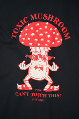 A close-up of a navy graphic t-shirt featuring a cartoon red mushroom character with the text 'TOXIC MUSHROOM CAN'T TOUCH THIS! EXPLORE' in red.
