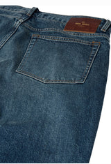 Close-up of blue jeans with a brand label on a white background