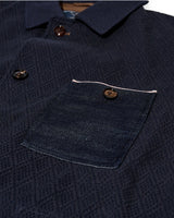Close-up of a navy blue textured shirt with a pocket and buttons.
