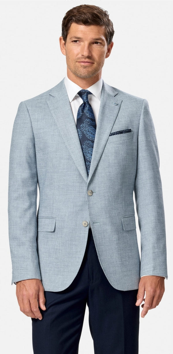 Man wearing a light blue suit with a patterned tie on a white background