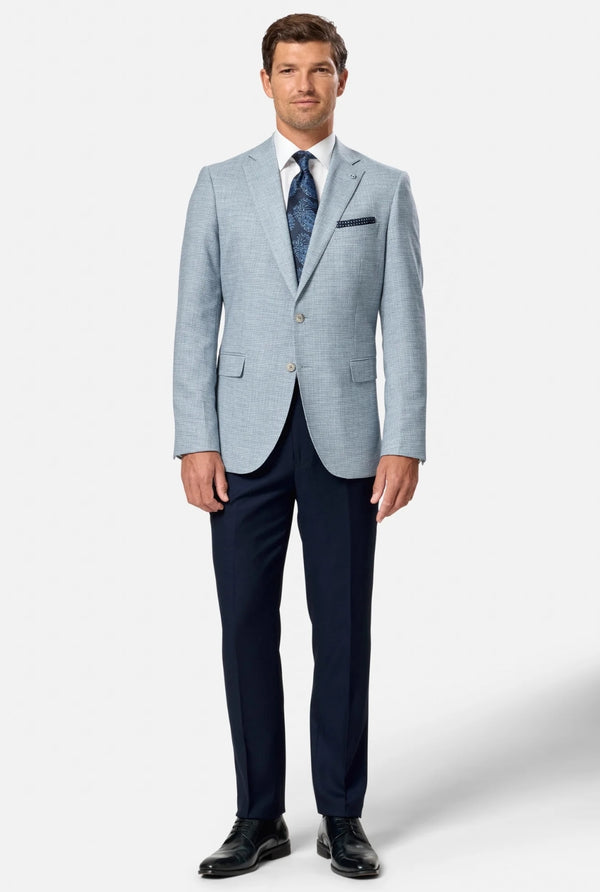 Man wearing a light blue checkered blazer over a dark blue dress shirt with a white background