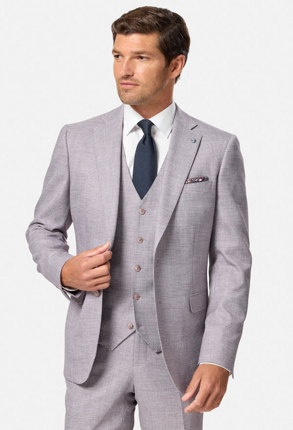 Man wearing a blush checkered suit with a white shirt and dark tie on a white background