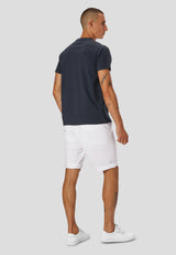 Man wearing a grey t-shirt and white shorts on a light gray background