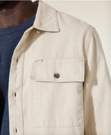 Beige jacket with a brand logo on a neutral background