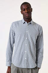 Man wearing a patterned shirt on a plain background