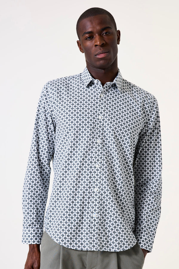 Man wearing a patterned shirt on a plain background